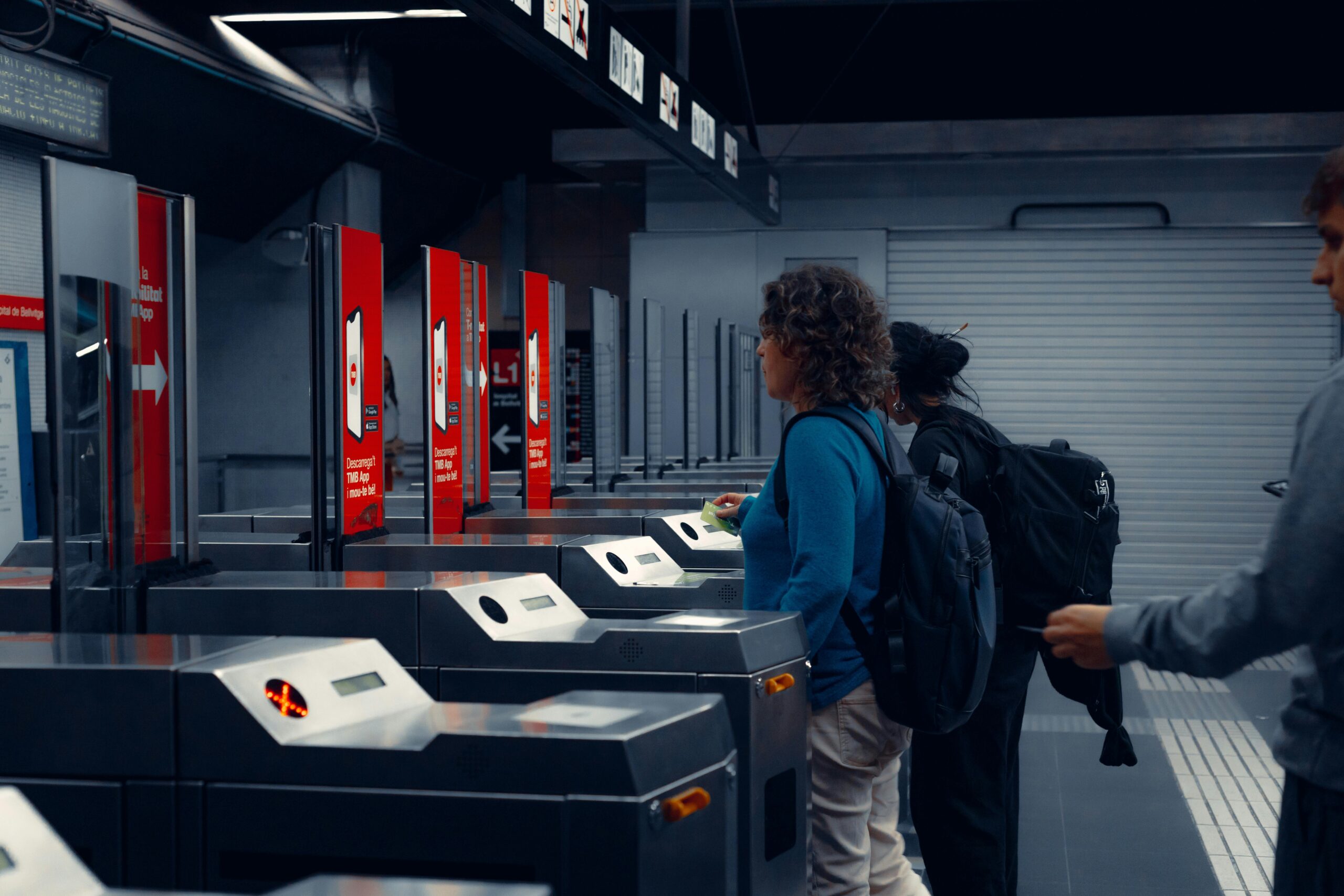 Urban commuters using turnstiles at a modern subway station, showcasing daily public transportation routine.